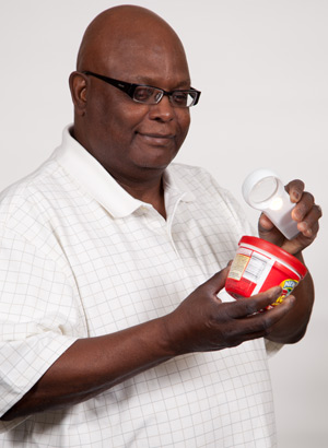 Man with macular degeneration reads label instructions with help of a magnifier